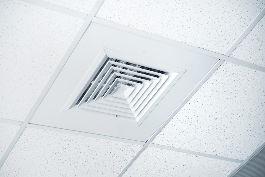 Rejilla de ventilación instalada en el techo, parte de un sistema de ventilación mecánica. Solución efectiva para cómo ventilar una habitación sin ventanas.
