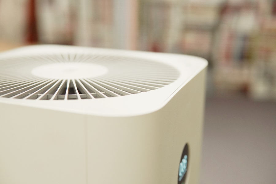 Purificador de aire en funcionamiento en un espacio cerrado. Dispositivo recomendado para cómo ventilar una habitación sin ventanas y mejorar la calidad del aire.