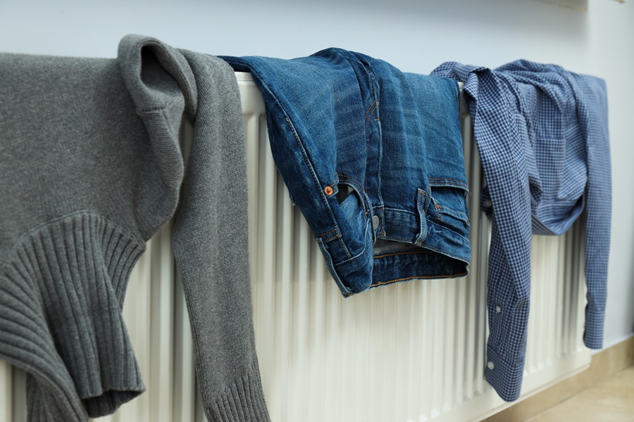 Prendas húmedas secándose sobre un radiador en el interior del hogar. Ejemplo de una práctica poco recomendable que respalda por qué es malo tender la ropa dentro de casa.