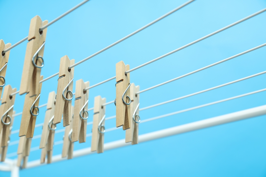 Pinzas de madera colgadas en un tendedero exterior, imagen para ilustrar a qué altura colocar tendedero según el tipo de instalación.