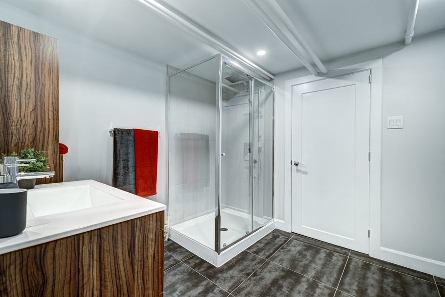 Baño moderno con mampara de cristal angular y grifería cromada, ejemplo de espacio cuidado donde se aplican técnicas para evitar sarro ducha.